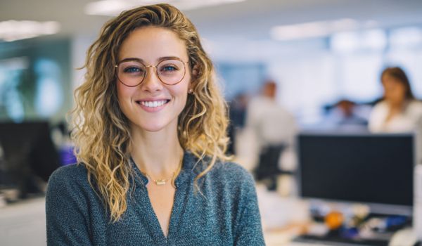 junge Frau im Büro lächelt in die Kamera
